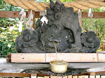 センサー付きの獅子の彫刻がある手水舎